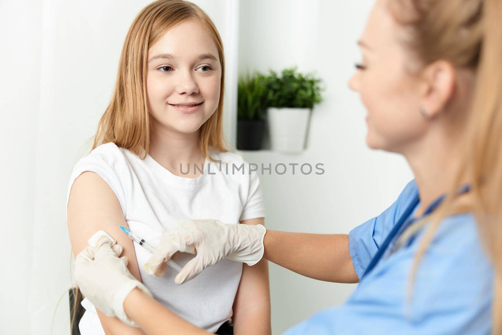 woman doctor giving a girl an injection in the arm health medicine. High quality photo