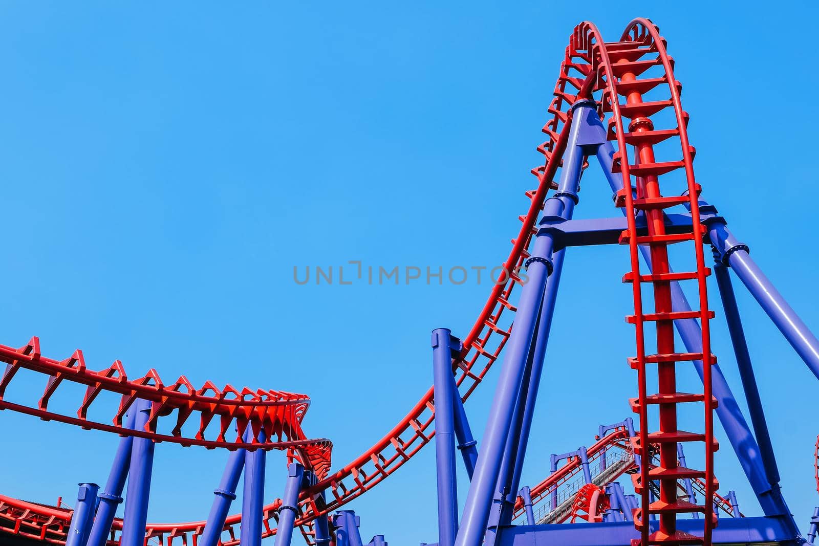 close-up image of a rollercoaster track and the blue sky