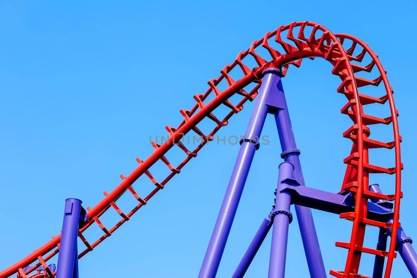 close-up image of a rollercoaster track and the blue sky