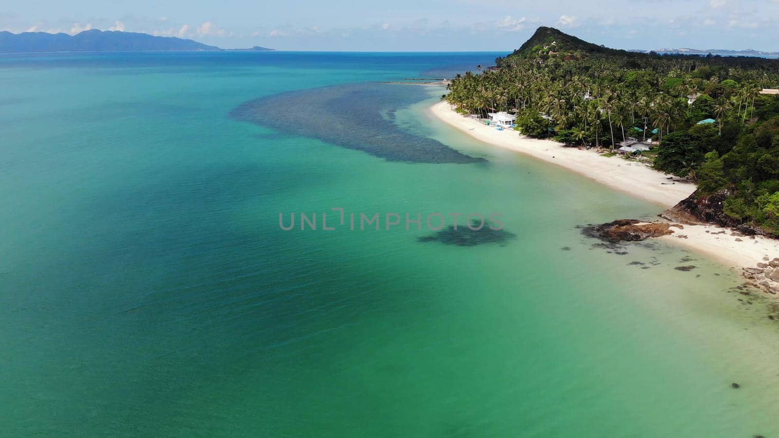 Green jungle and stony beach near sea. Tropical rainforest and rocks near calm blue sea on white sandy shore of Koh Samui paradise island, Thailand. Dream beach drone view. Relax and holiday concept