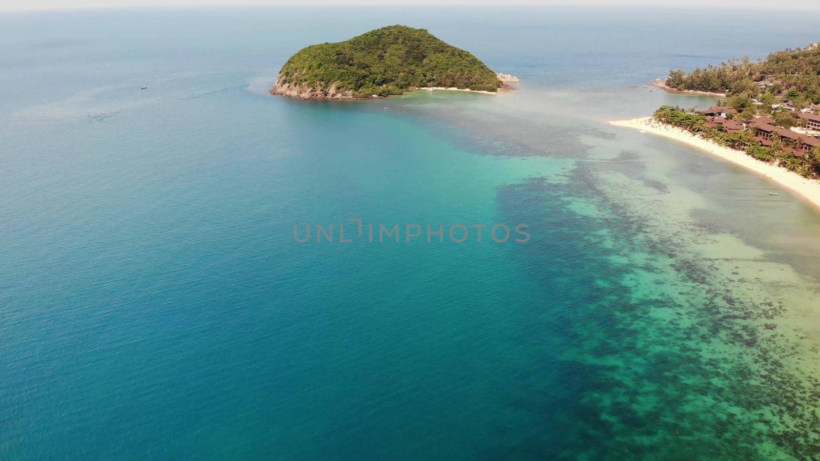 Aerial drone view small Koh Ma island, Ko Phangan Thailand. Exotic coast panoramic landscape, Mae Haad beach, summer day. Sandy path between corals. Vivid seascape, mountain coconut palms from above