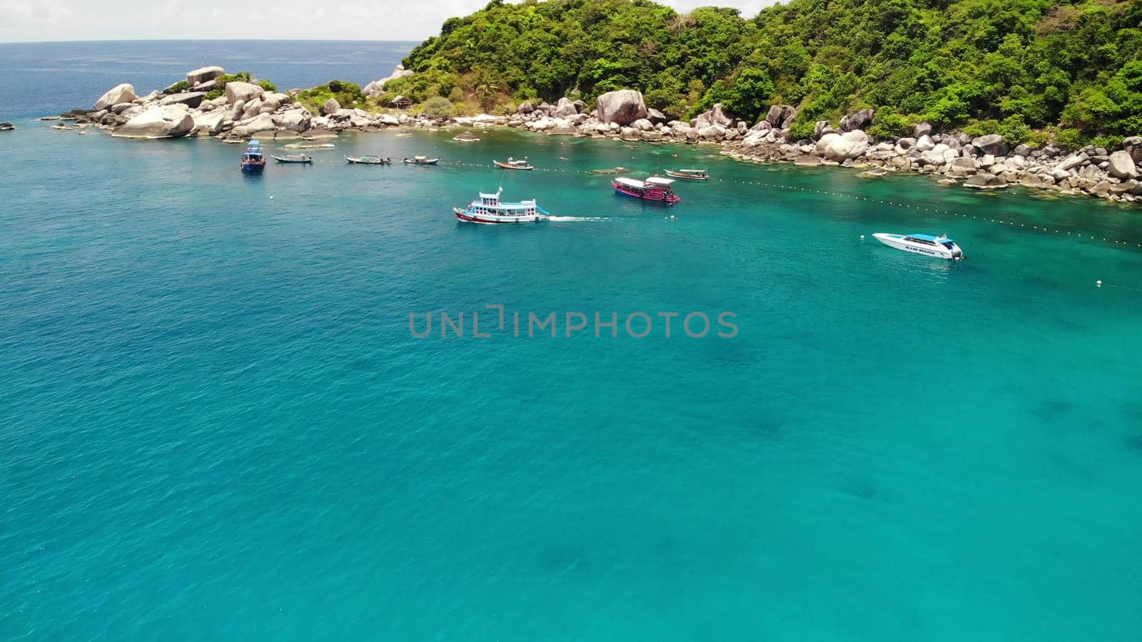 Tourist boats in tropical bay. Drone view of tourist boats with divers and snorkelers floating on calm sea water in Hin Wong Bay of tropical volcanic Koh Tao Island in Thailand