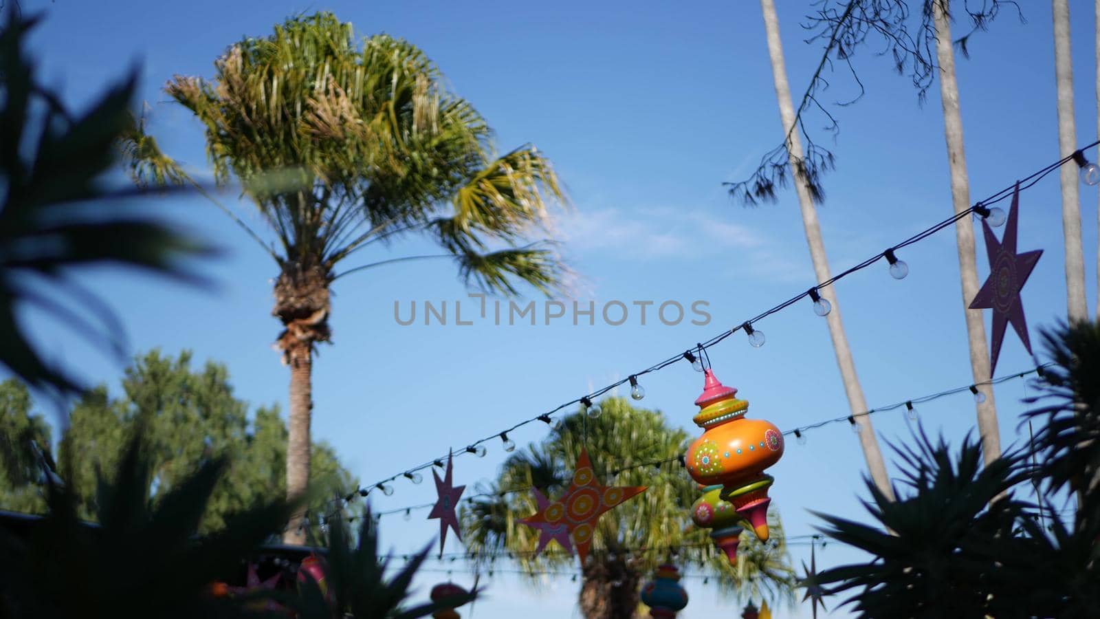 Festive mexican colourful decoration for holiday. Festival authentic decor in garden, details of garland with light bulbs in San Diego, California USA. Festal multi colored traditional celebration.