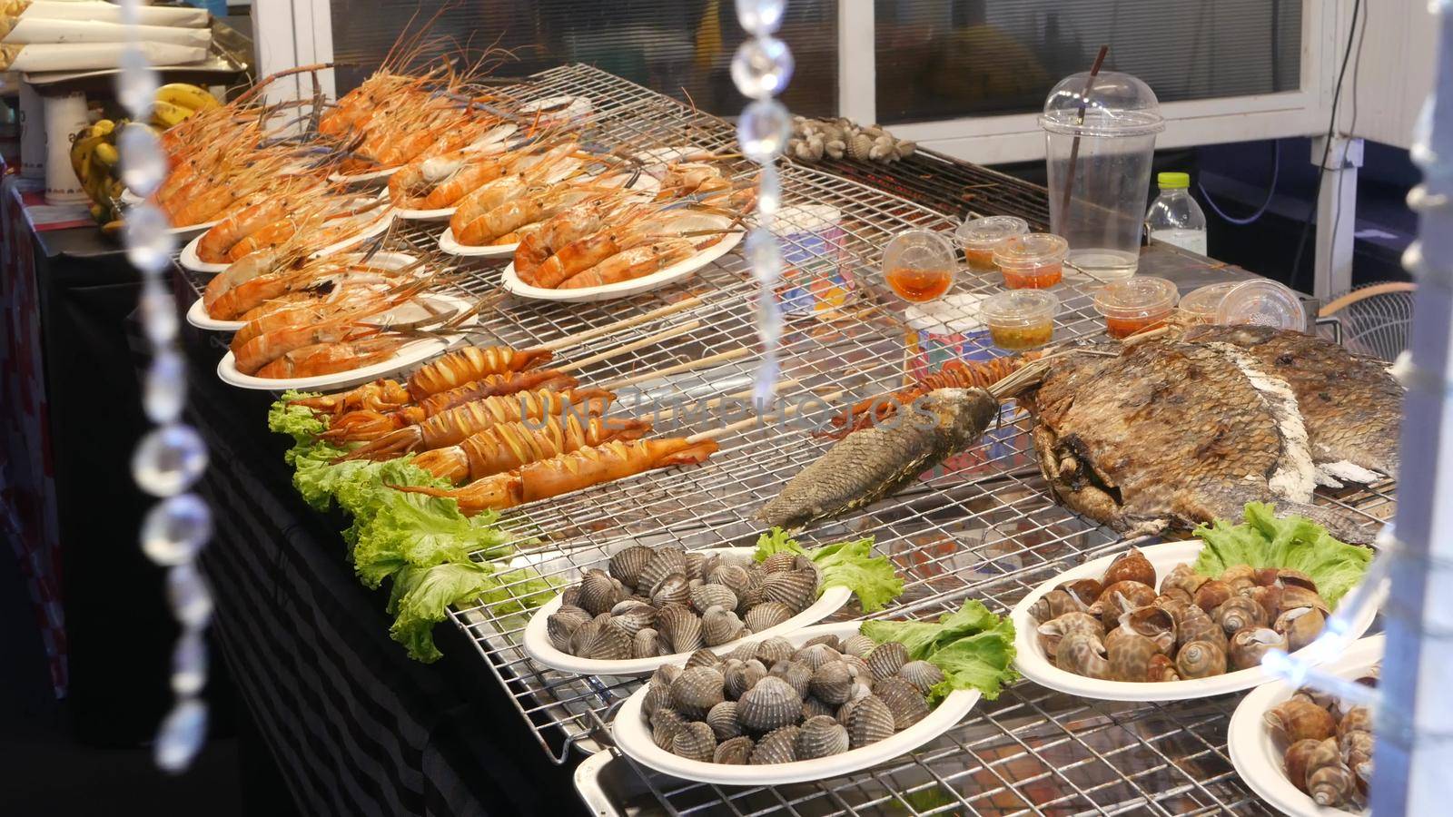 National Asian Exotic ready to eat seafood at night street market food court in Thailand. Delicious Grilled Prawns or Shrimps and other snacks