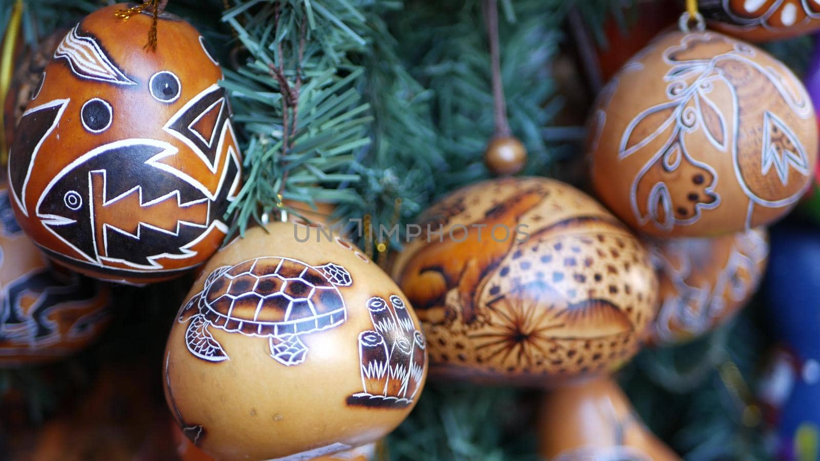 Wooden ornamental handmade mexican decor. Indigenous souvenirs hanging on new year tree, handicraft market, California USA. Hispanic authentic pattern, folk traditional handiwork from Latin America.