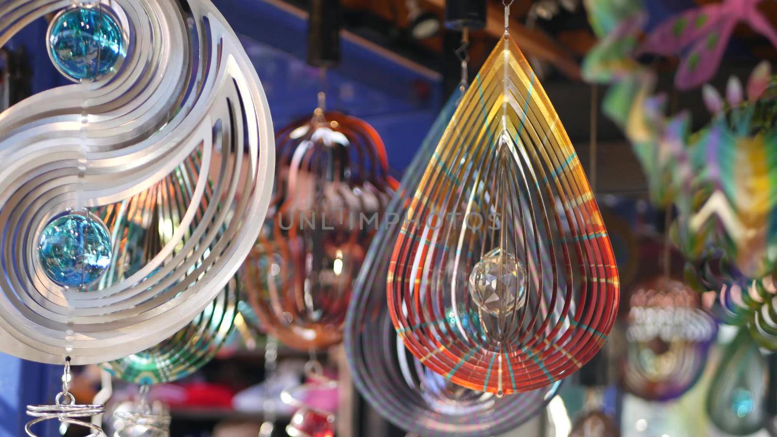 Colorful geometric metallic wind spinner, garden hypnotic surreal decoration, California USA. 3D kinetic rotating iridescent magnetic multi colored air spiral. Shimmering mesmerising optical illusion.
