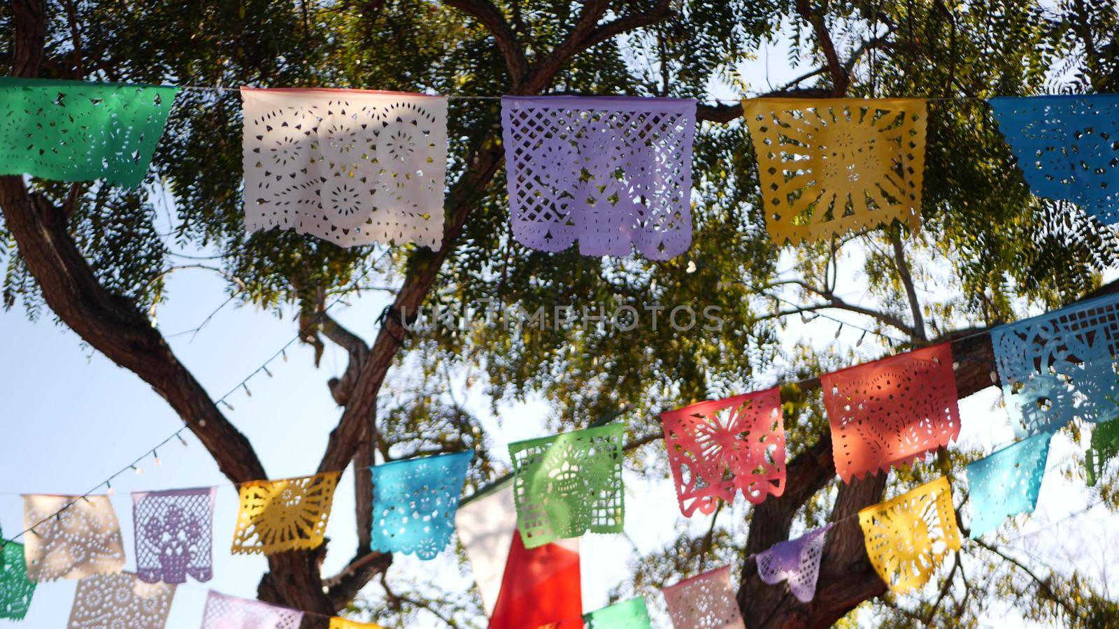Colorful mexican perforated papel picado banner, festival colourful paper garland. Multi colored hispanic folk carved tissue flags, holiday or carnival. Authentic fiesta decoration in Latin America.