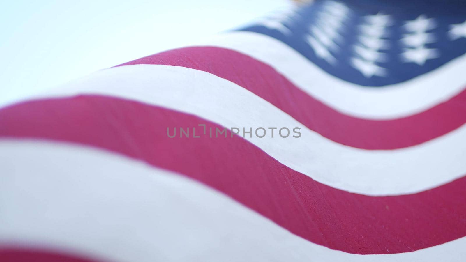 Soft focus close up of American Old Glory flag waving on wind. Stars and Stripes democracy, patriotism, freedom and Independence Day symbol. Star-spangled Banner, national pride and icon of liberty.