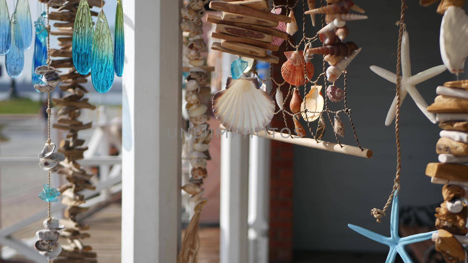 Nautical style hanging seashells decoration, beachfront blue wooden holiday home, pacific coast, California USA. Marine pastel interior decor of beach house in breeze. Summertime sea wind aesthetic.