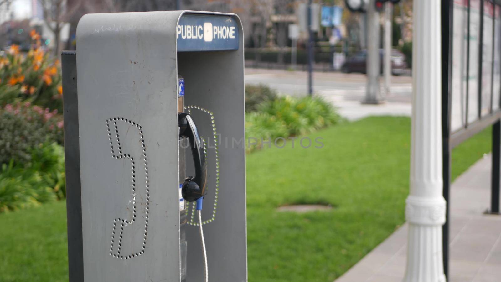 Retro coin-operated payphone station for emergency call on street, California USA. Public analog pay phone booth. Outdated technology for connection and telecommunication service. Cell handset on box.