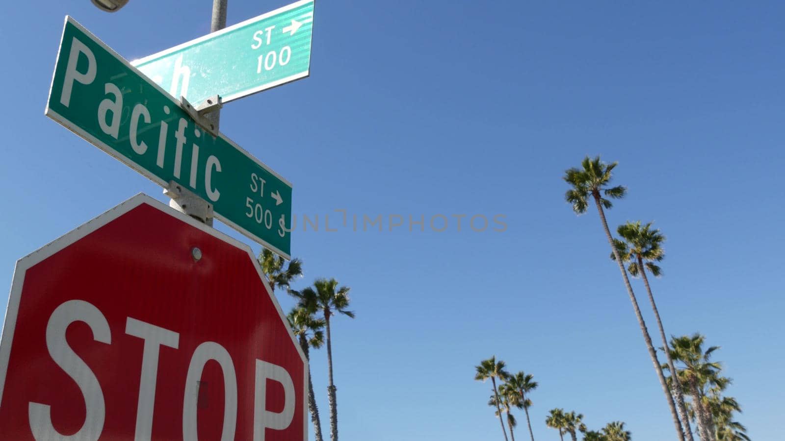 Pacific street road sign on crossroad, route 101 tourist destination, California, USA. Lettering on intersection signpost, symbol of summertime travel and vacations.Signboard in city near Los Angeles by DogoraSun