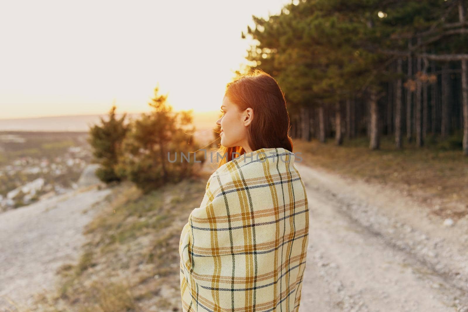 A woman on the road near the forest looks to the side and a plaid on her shoulders by SHOTPRIME