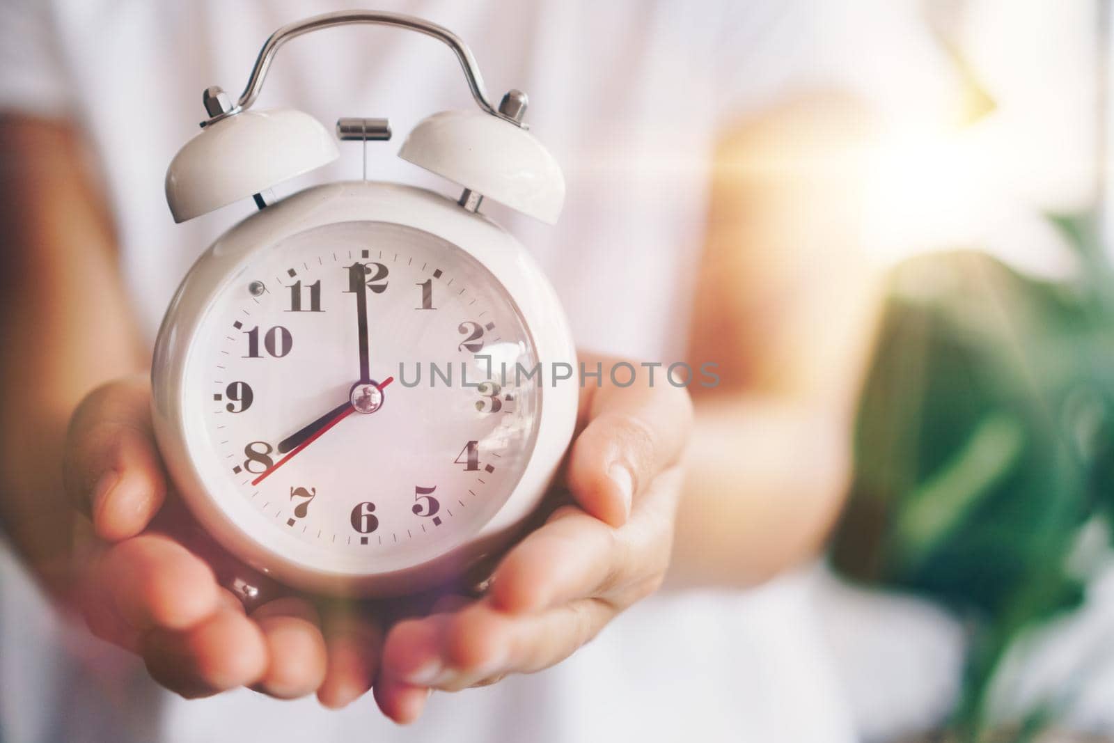 Selective focus of alarm clock with nature bokeh background. lifestyle  productive life concept.