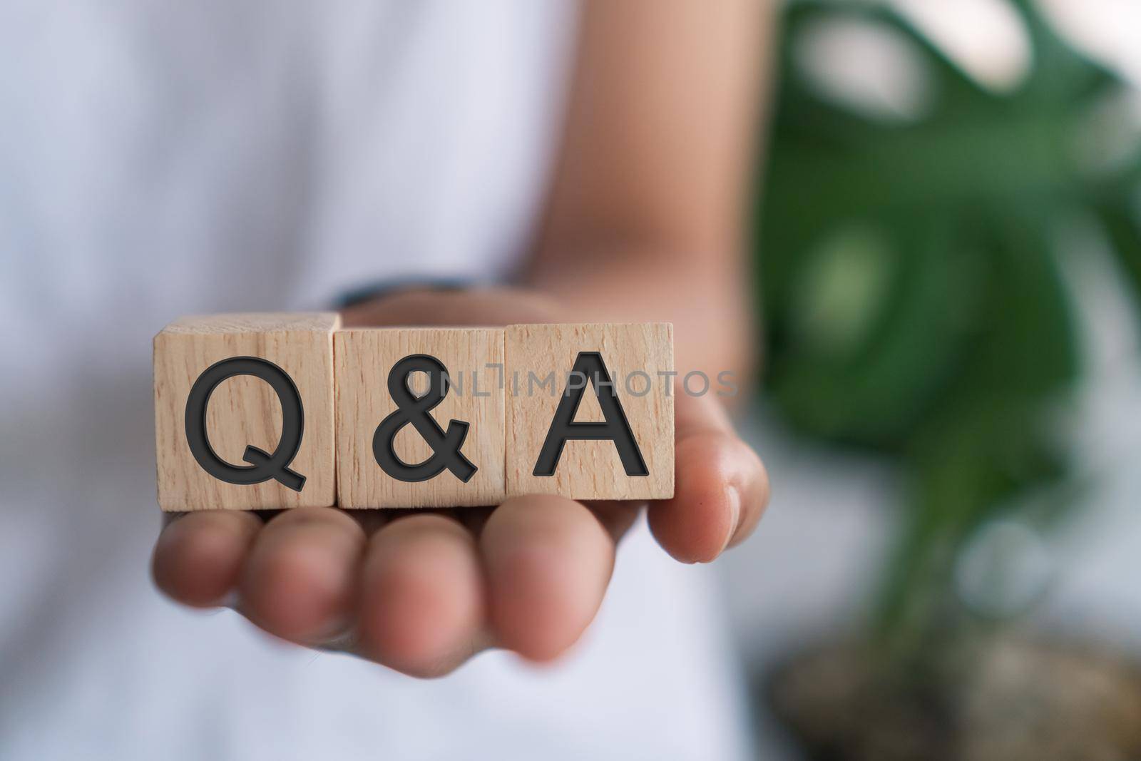 Q and A alphabet on wooden cube in hand hold with background. Question and answer meaning. by Suwant