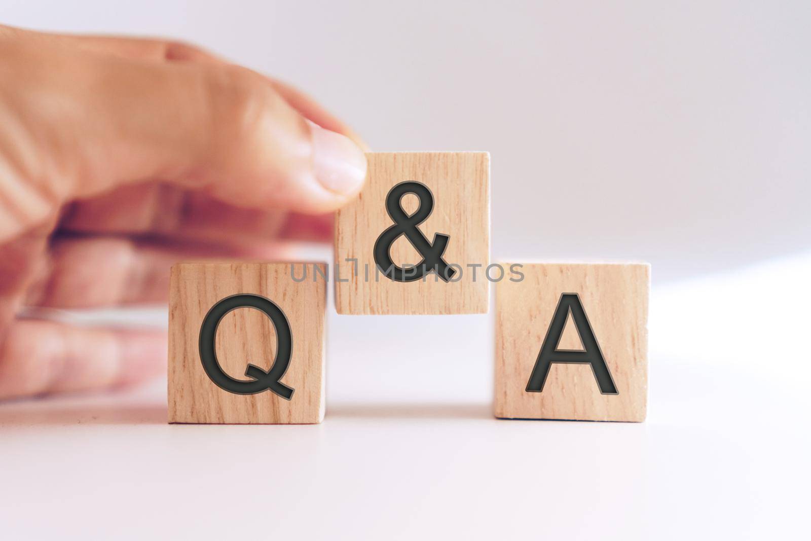 Q and A alphabet on wooden cube in hand hold with background. Question and answer meaning. by Suwant