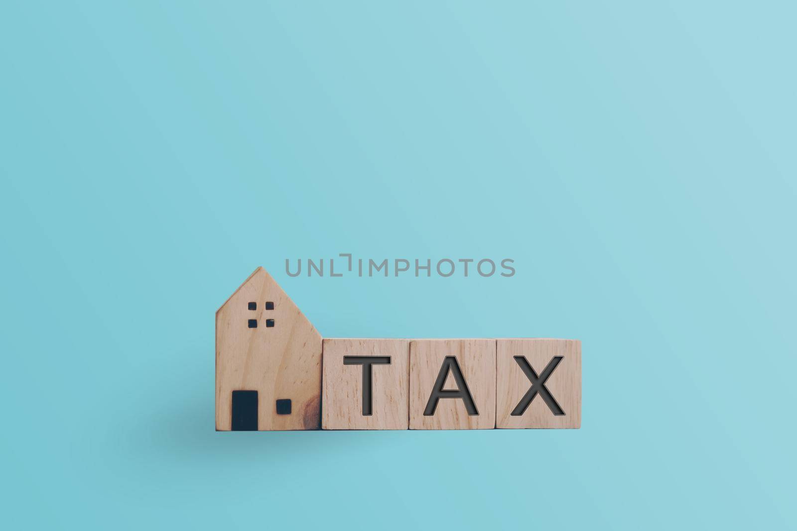 Tax word on wooden cube background. Business financial loan property concept.