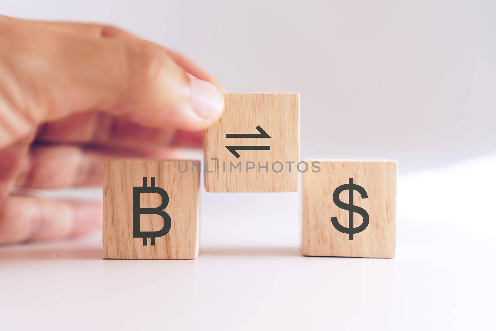 Bitcoin trade or exchange to dollar sign in stock market on wooden cube with hand hold it. Business finance future digital gold money concept background.