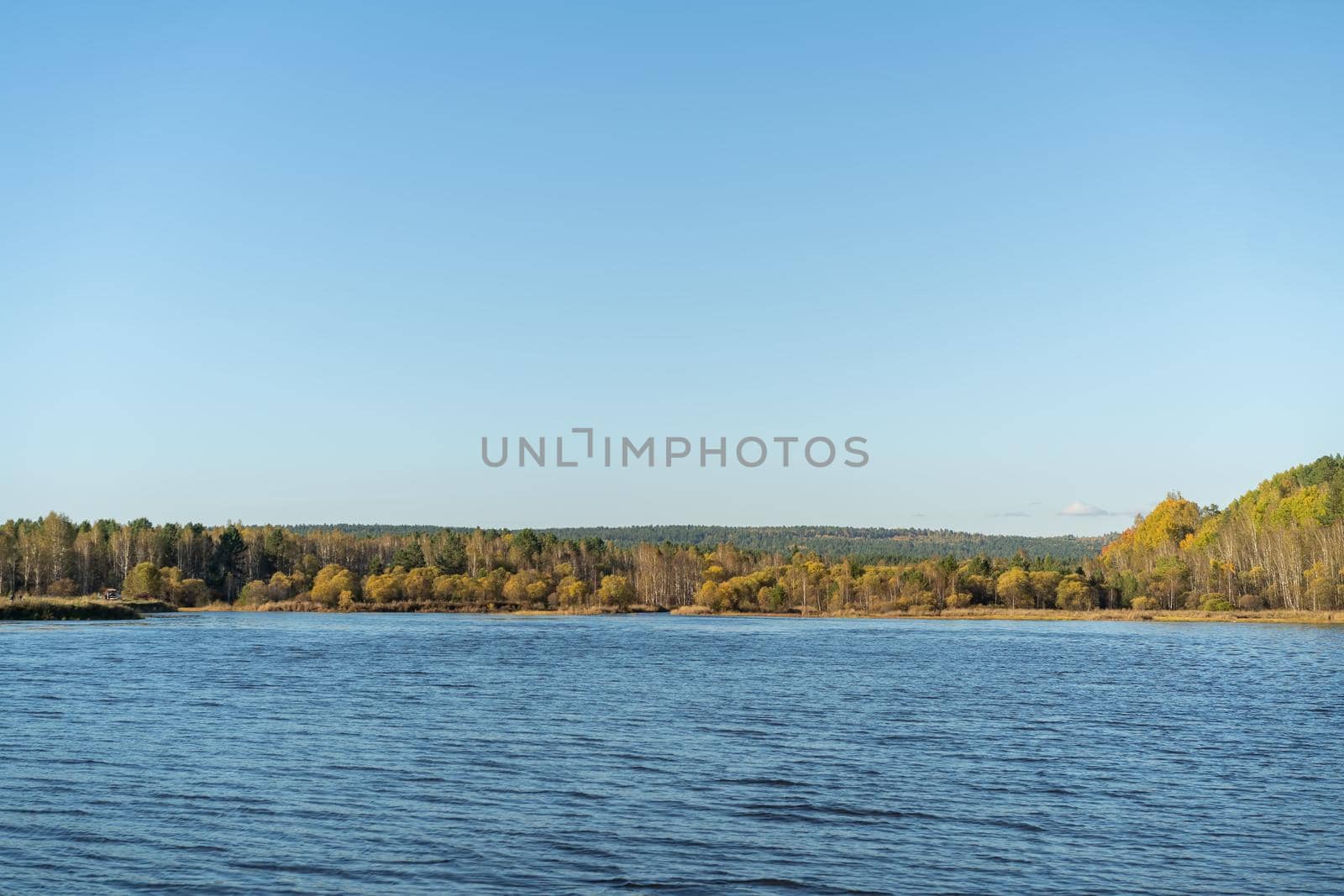 Natural landscape with a lake and autumn trees on the shore. Travel, tourism