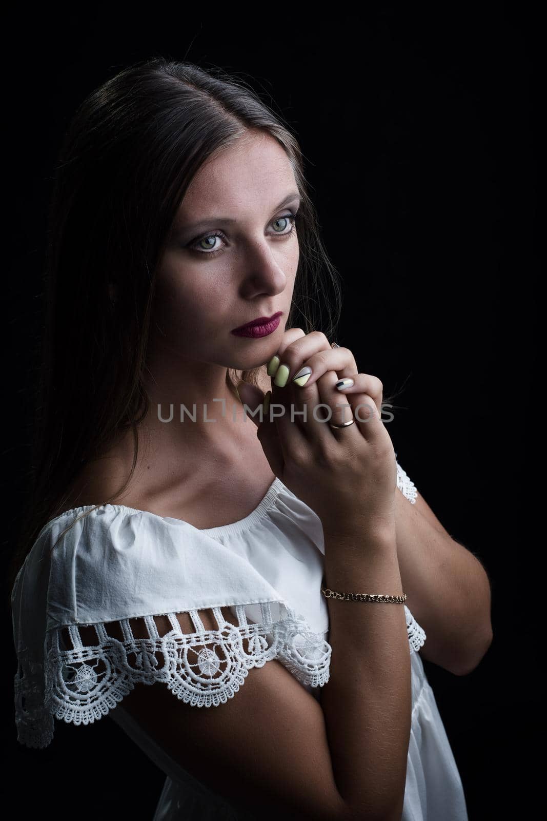 Portrait of a beautiful girl thoughtfully putting her hands to her chin