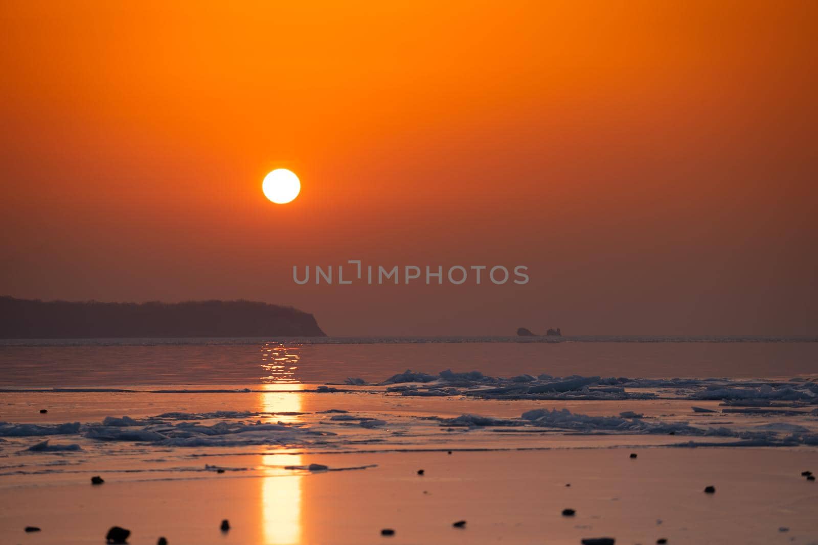 Seascape ice beach and the red sunset.