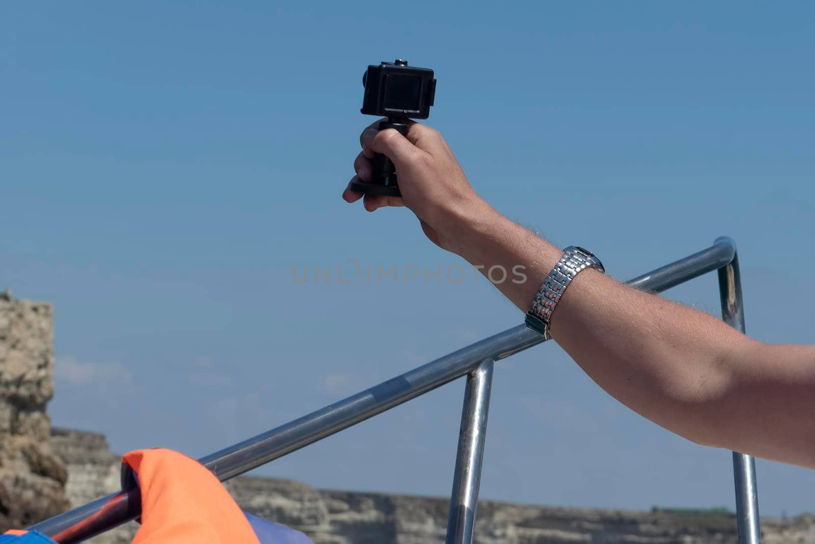 Landscape with male hand view with action camera.