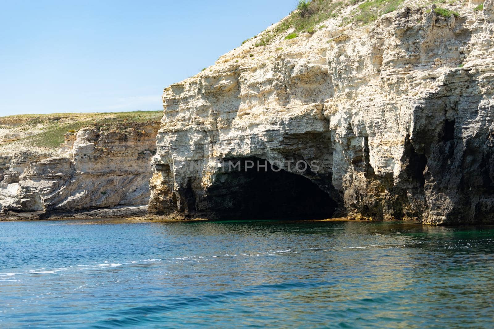 Beautiful view of us we are with the rocky shore of the black sea and the green-blue water on a Sunny summer cloudless day. Tarkhankut national reserve. Republic Of Crimea