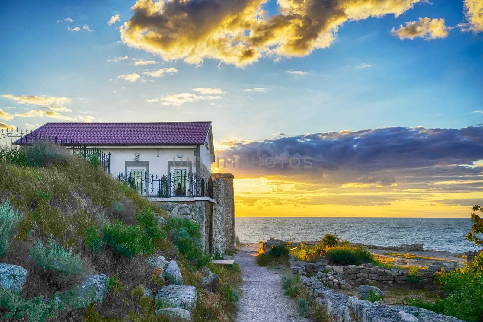 little house by the sea during sunset under the clouds
