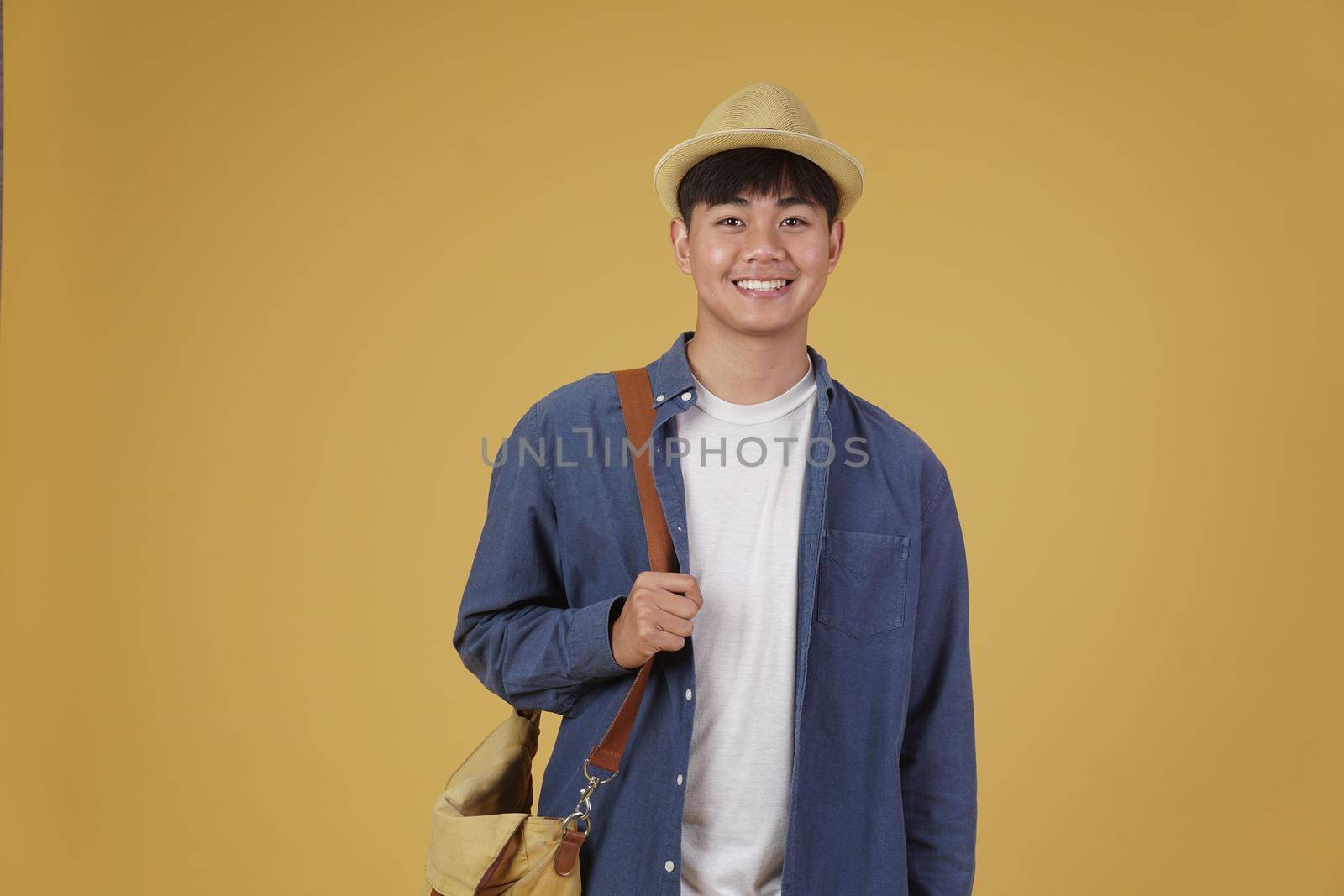 young asian man traveler smiling isolated on yellow background. Travel journey trip in holiday vacation