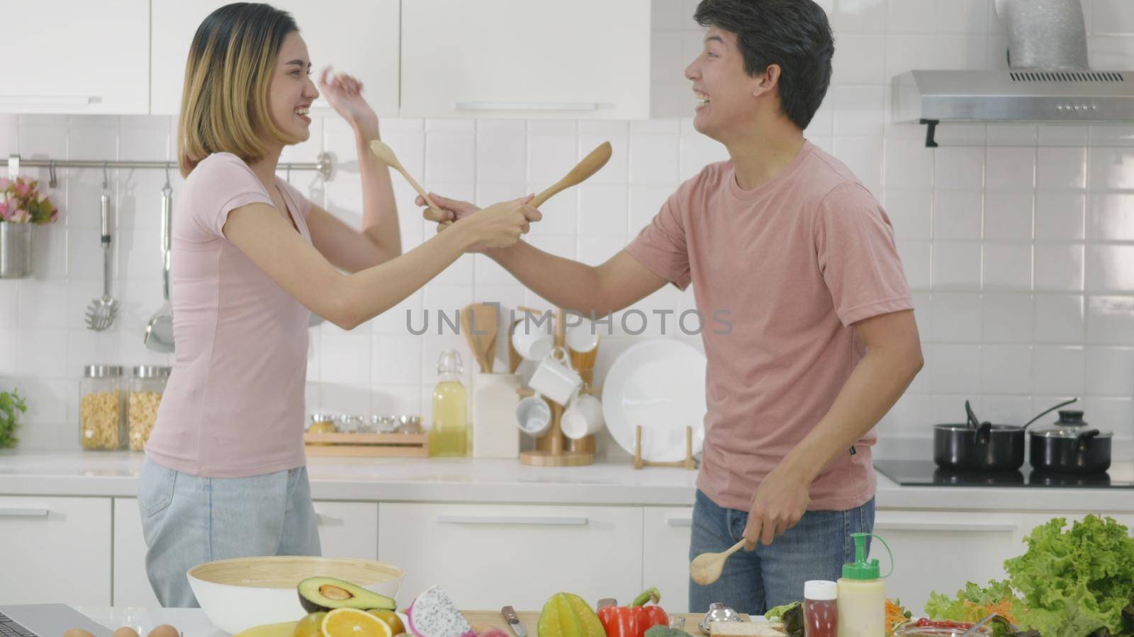 couple husband and wife singing in kitchenware microphones in kitchen by Sorapop