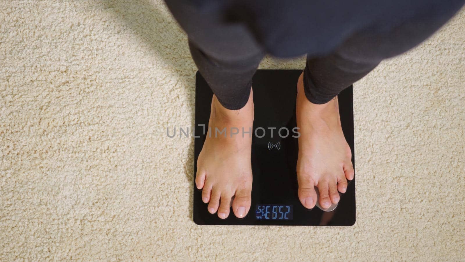 woman leg stepping standing on floor electric scales by Sorapop