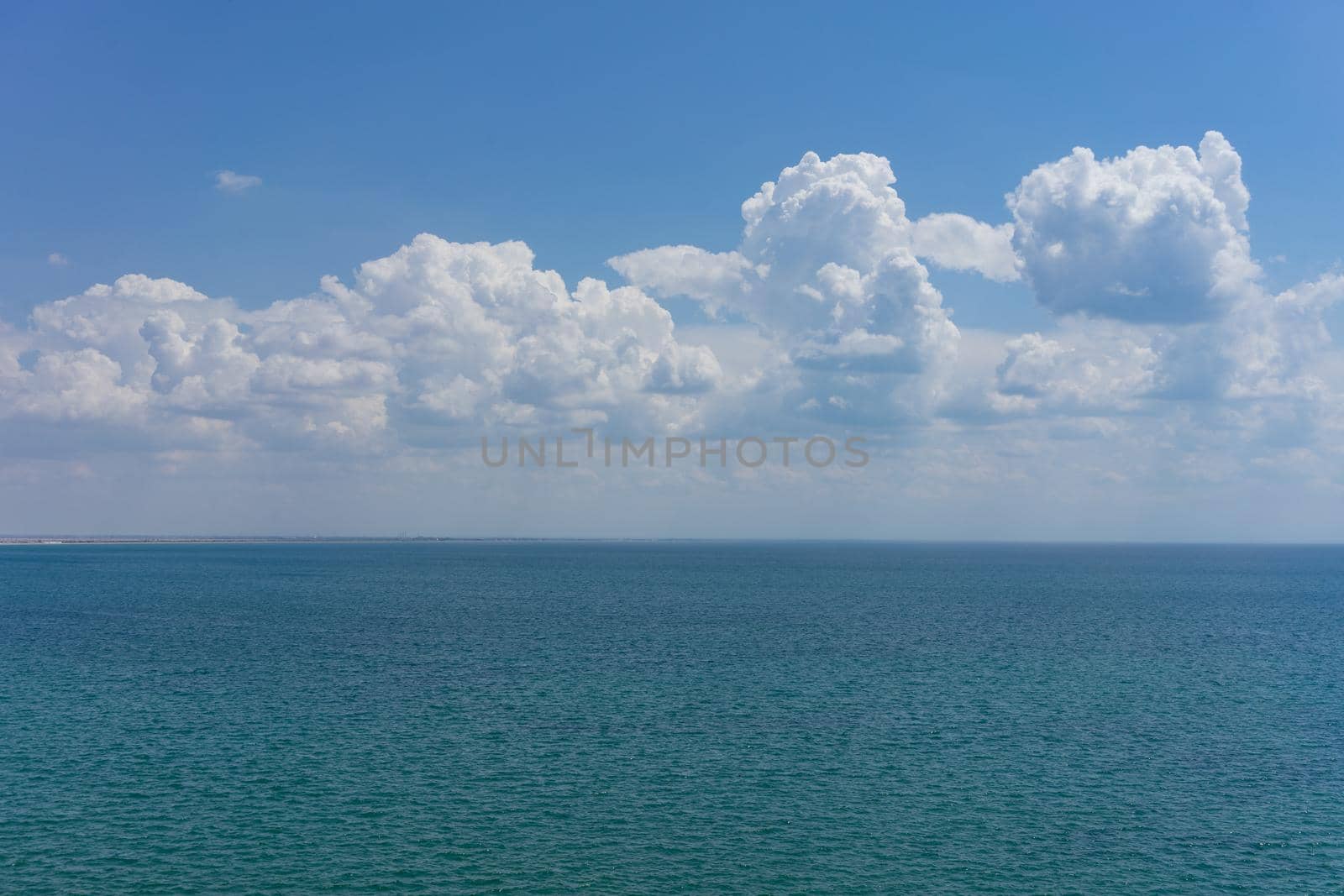 Seascape with water surface and sky with clouds.