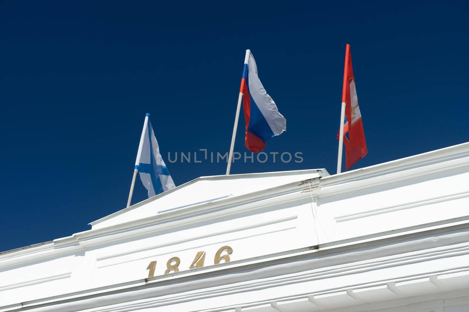 Sevasopol, Crimea. Flags on top of a white colonnade against a blue sky.