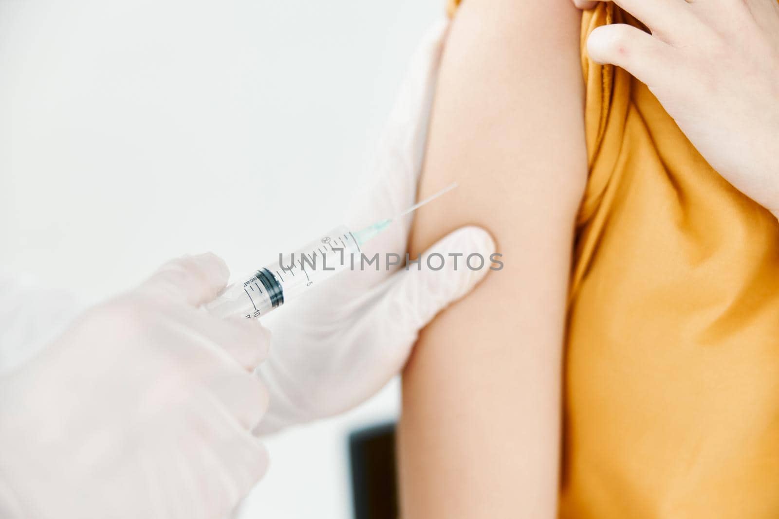 a doctor injects a covid-19 vaccine into a woman's shoulder. High quality photo