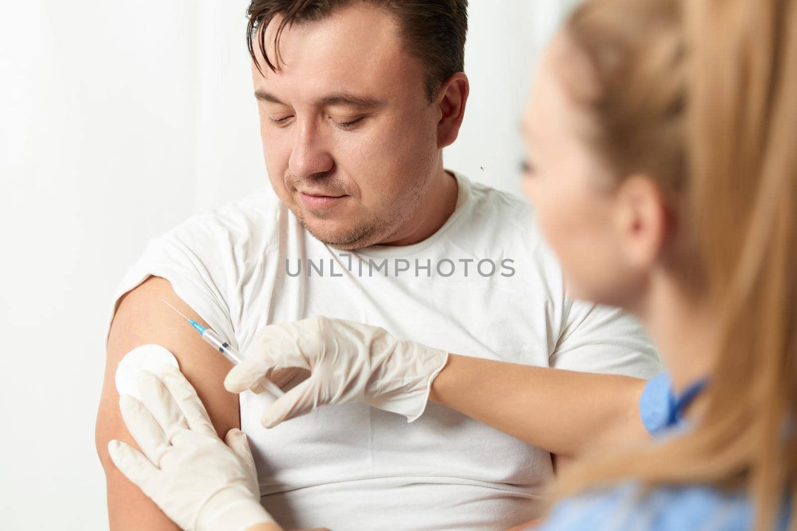 woman doctor injecting man into arm health hospital. High quality photo