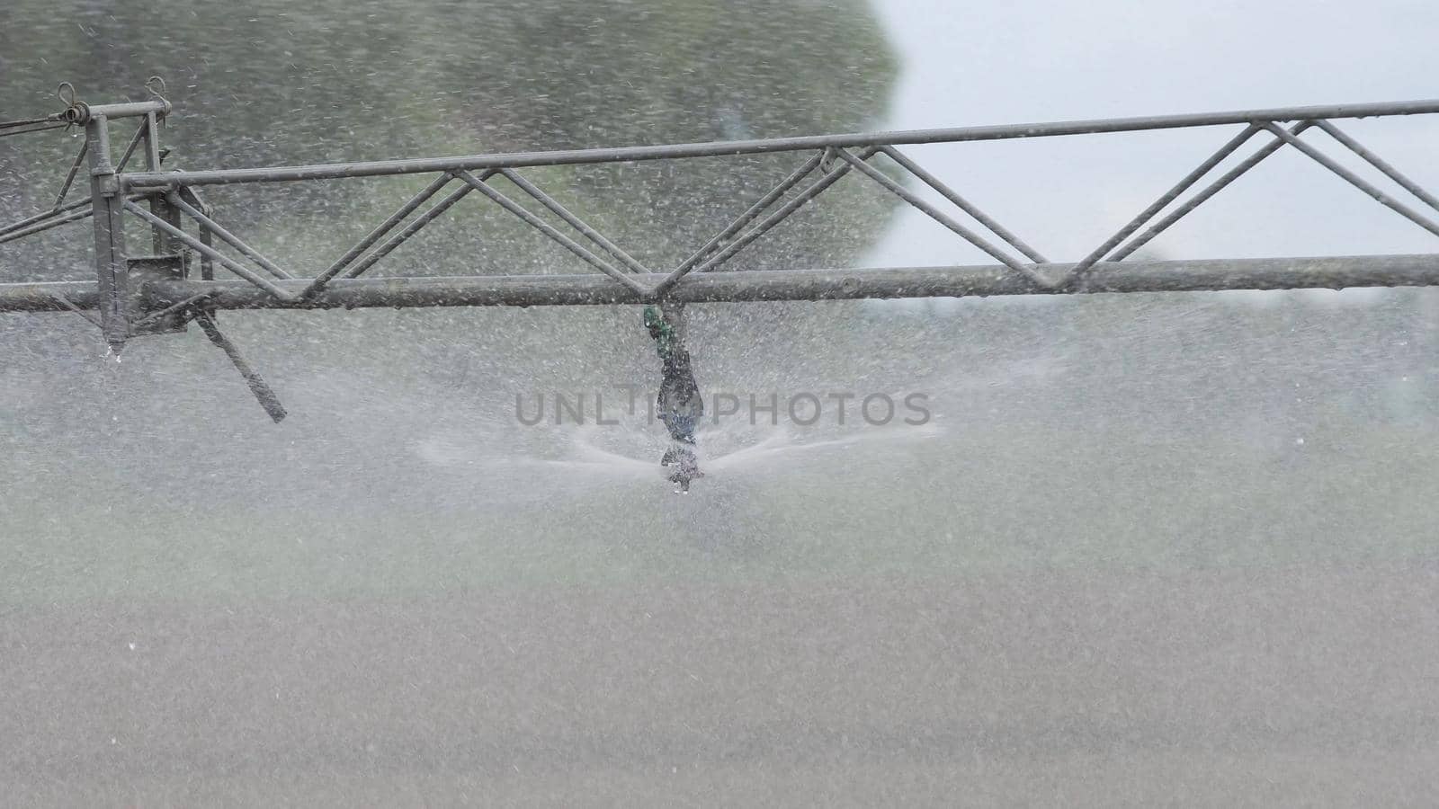 Aerial view: Crop Irrigation using the center pivot sprinkler system. An irrigation pivot watering salad, lettuce field. Irrigation system watering farm field.