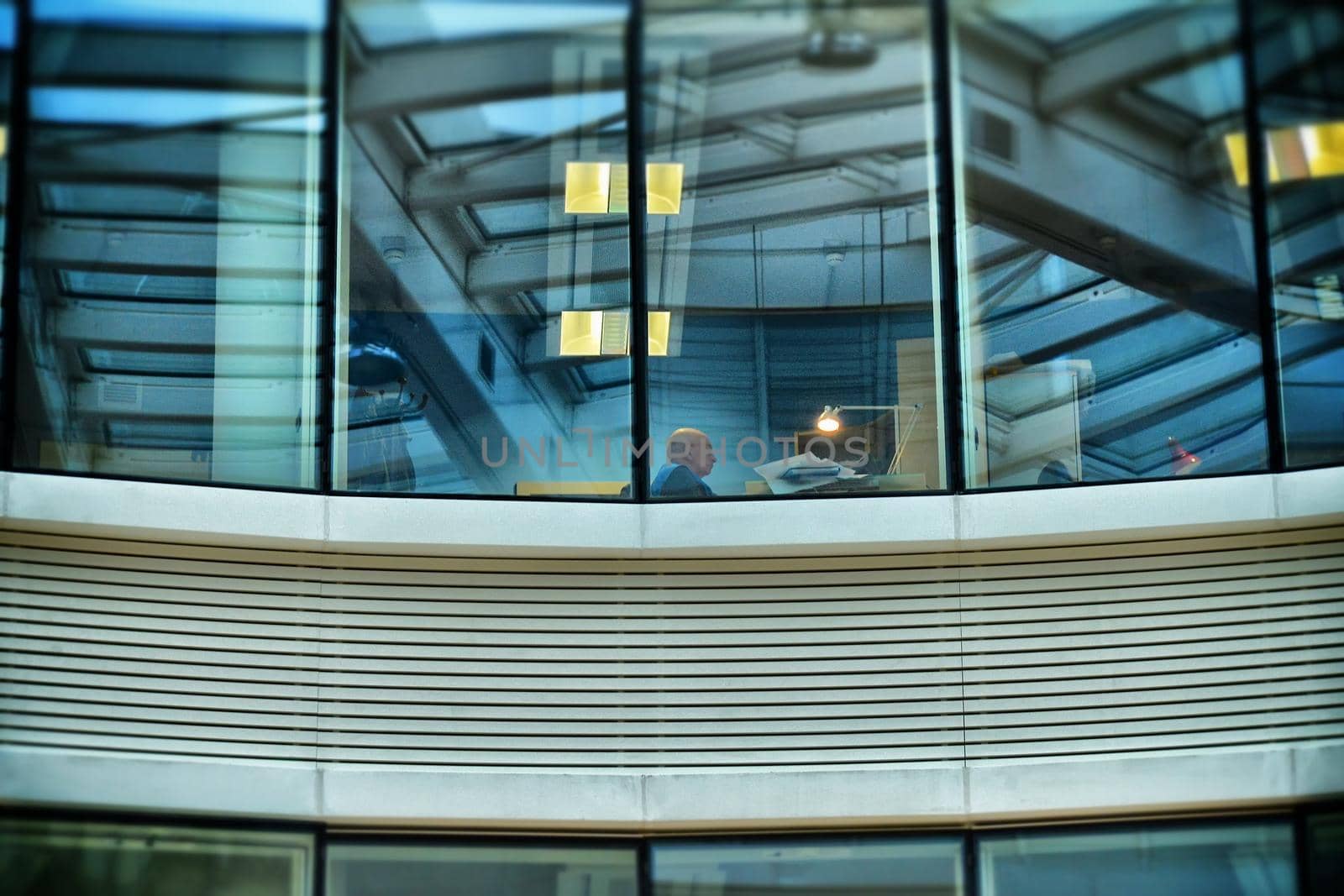 Lonely worker in office exterior view through the window Turin Italy circa October 2015 by lemar