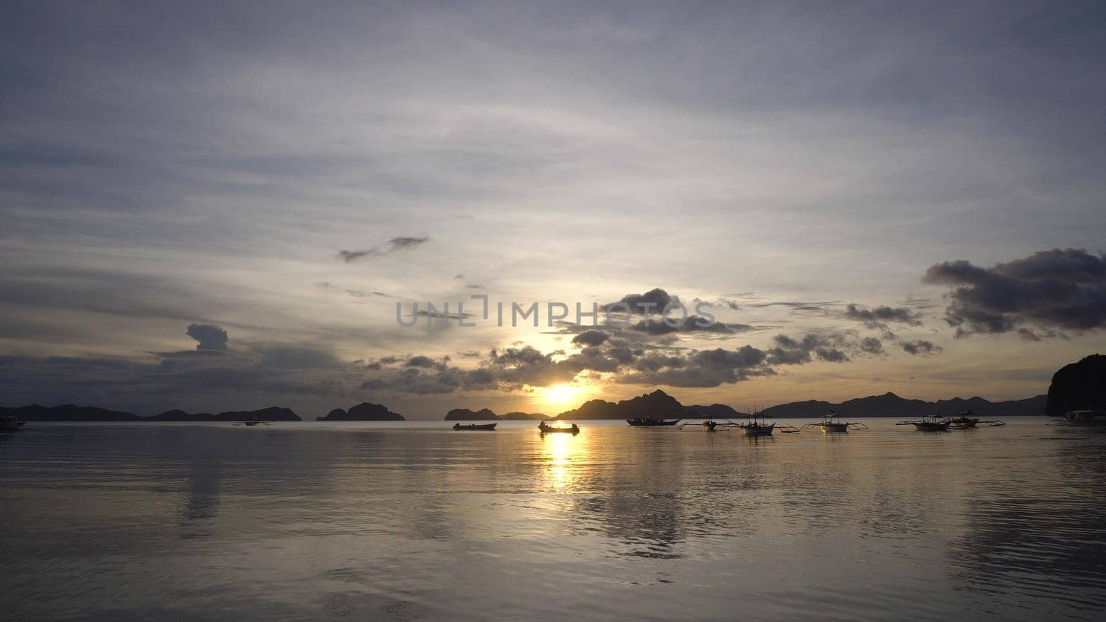 Marine tropical sunset over the sea. Sunset over the sea in the background boats, orange sky and islands. Travel concept. Nothing but sky, clouds and water. Beautiful serene scene.