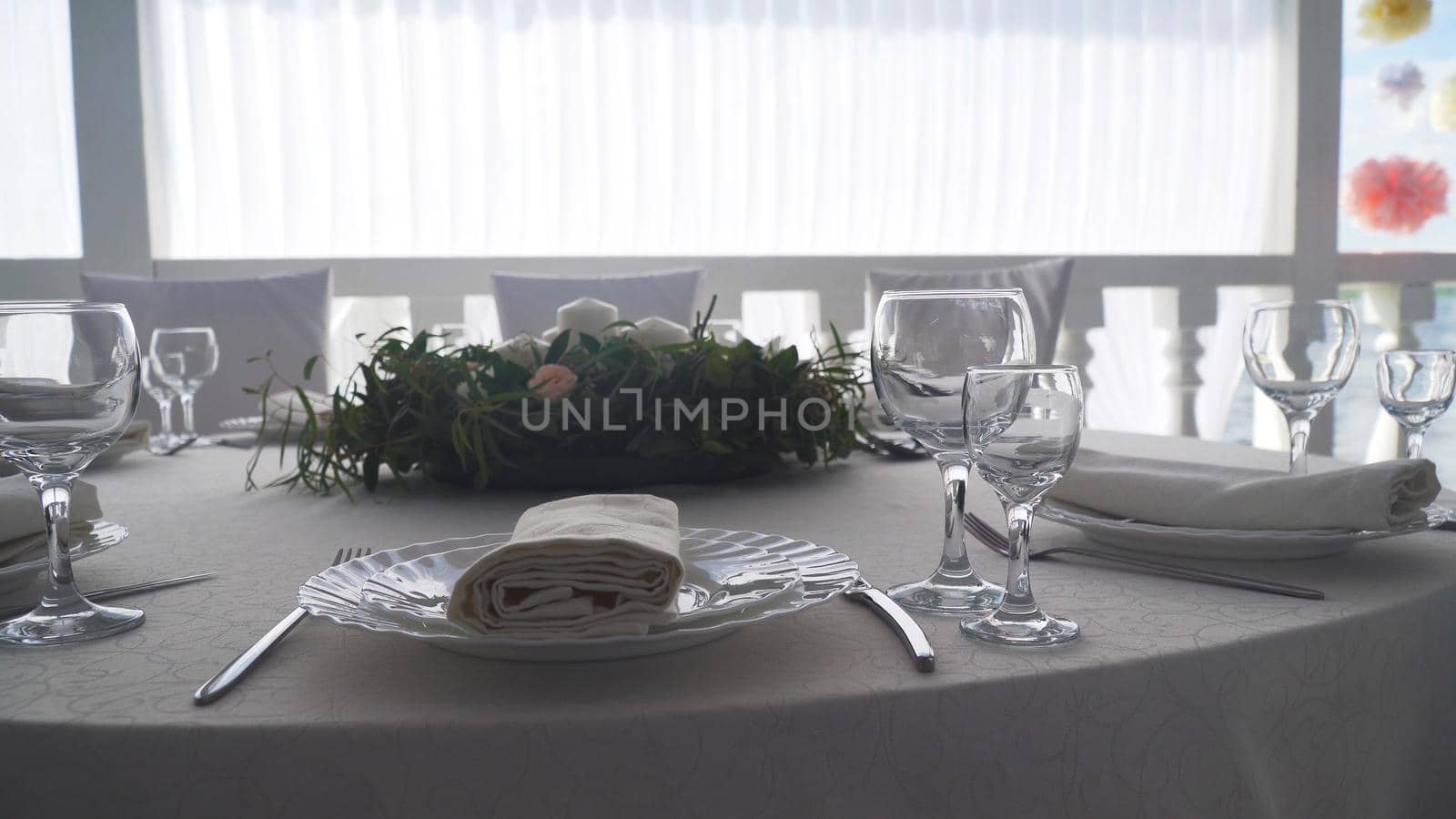Banquet decorated table, with cutlery. Wedding decor in the banquet hall.Serving of a festive table, plate, napkin, knife, fork. Table setting decoration. Romantic Dinner or other events.