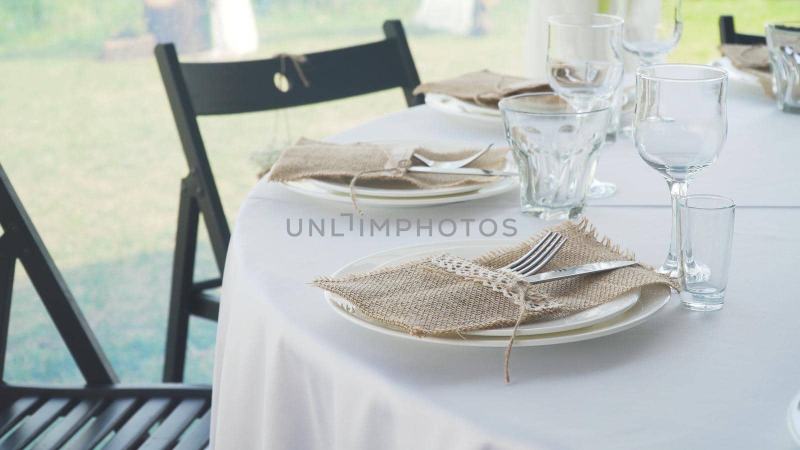 Banquet decorated table, with cutlery. Serving of a festive table, plate, napkin, knife, fork. Table setting decoration. Romantic Dinner or other events.