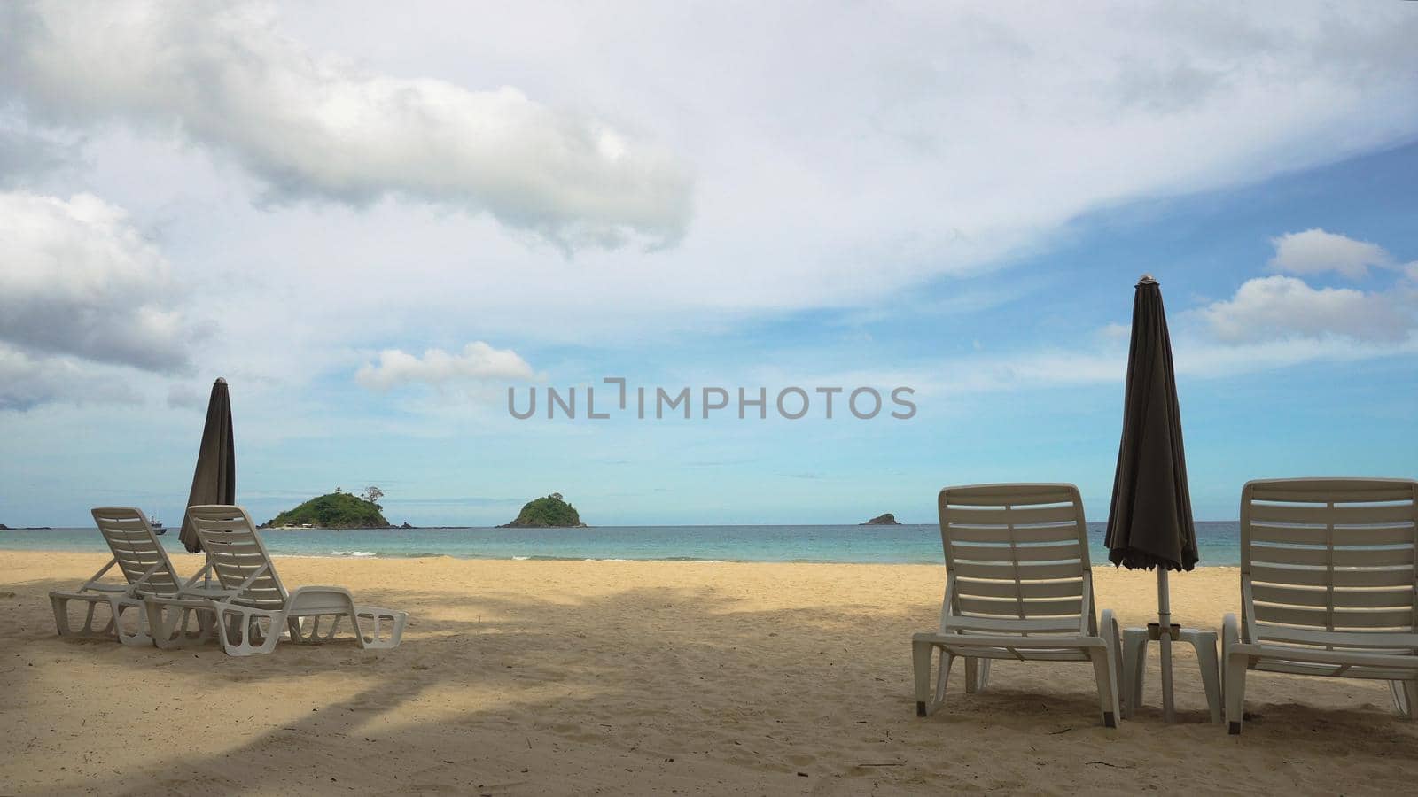 Beach with deck chairs, sun beds, umbrellas. Beach, sea, sand,wave. Seascape ocean and beautiful beach paradise, blue sky, clouds. Philippines El Nido Travel concept