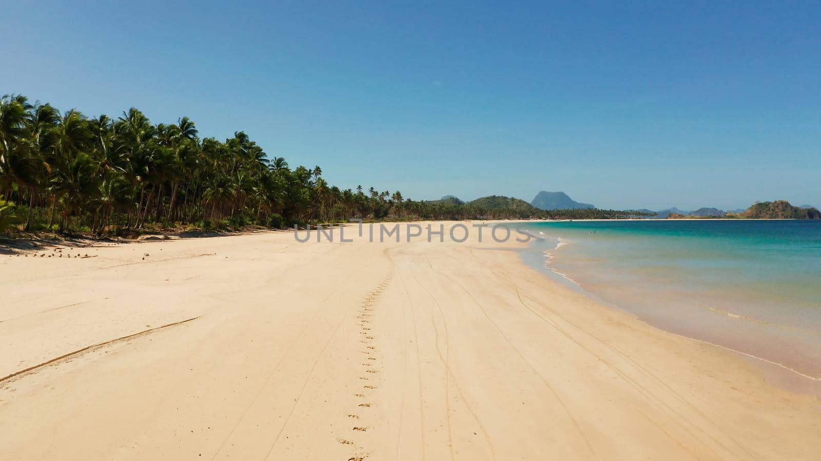 Wide sand beach Nacpan Beach, aerial view. El Nido, Palawan, Philippine Islands. Seascape with tropical beach and islands. Summer and travel vacation concept
