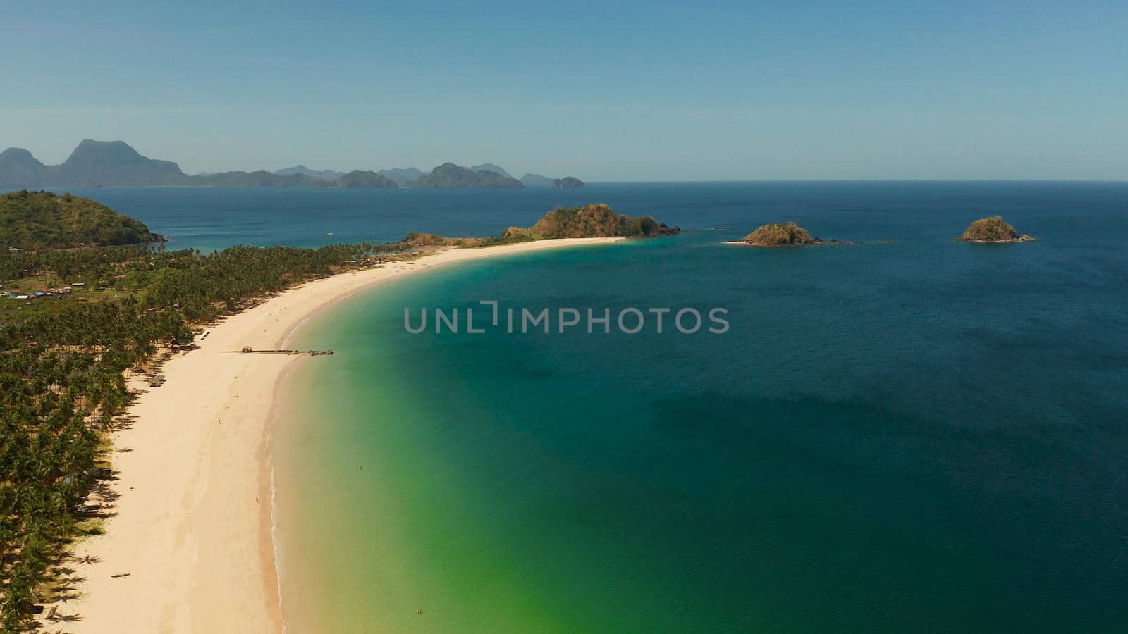 Blue sea and tropical beach, aerial drone. Nacpan, El Nido, Palawan, Philippine Islands. Seascape with tropical beach and islands. Summer and travel vacation concept