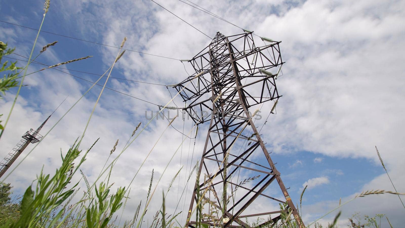 High voltage post.High-voltage tower sky background. High-voltage electrical insulator electric line against the blue sky. Electricity transmission power lines.