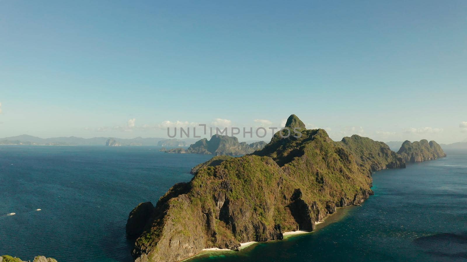 Seascape with tropical rocky islands, ocean blue water, aerial view . islands and mountains covered with tropical forest. El nido, Philippines, Palawan. Tropical Mountain Range