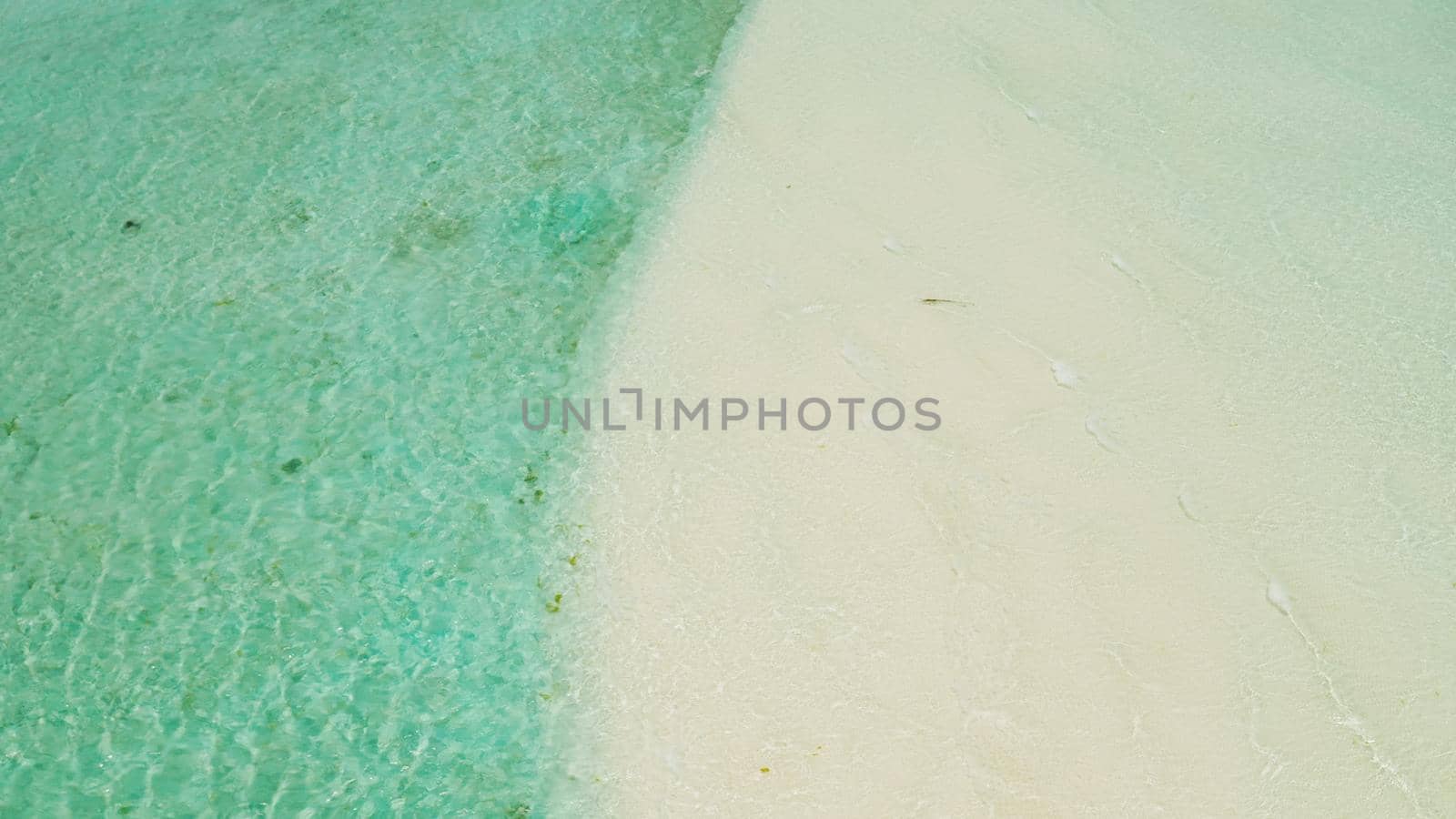 Tropical sandy beach with wave and turquoise water,copy space for text, aerial view. Sea water surface in lagoon. Transparent turquoise ocean water surface. Background texture