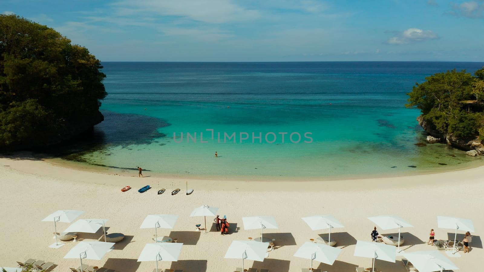 Tropical sandy beach with sun beds near the lagoon with turquoise water from above, Boracay, Philippines, aerial view. Seascape with beach on tropical island. Summer and travel vacation concept.