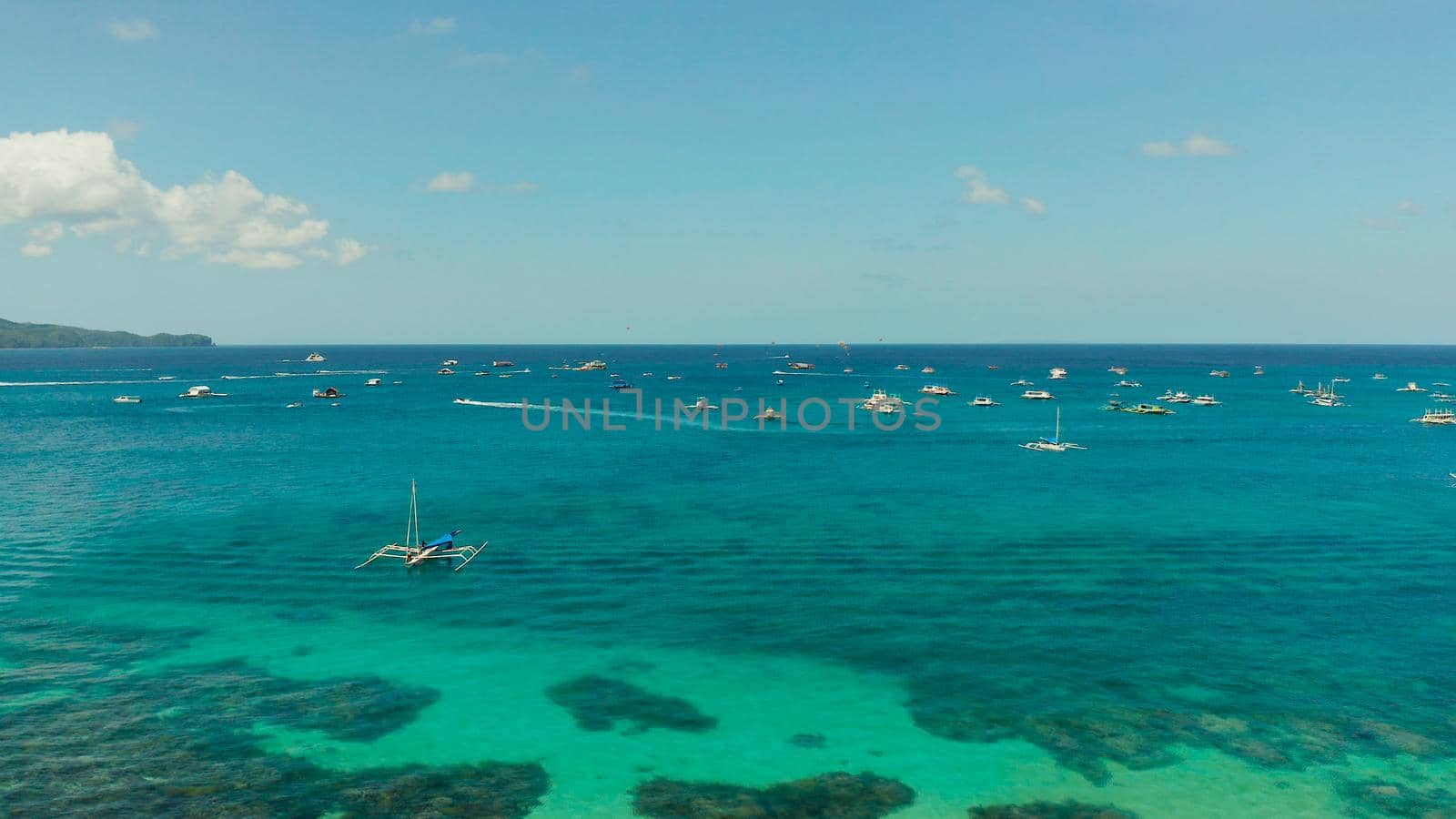Water park on the island of Boracay, inflatable banana, jet ski, parasailing. Water sports and recreation on a tropical island. Water Activities. Sea attraction
