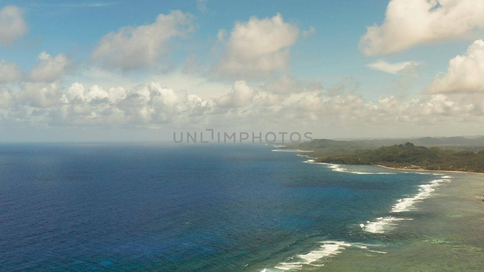 Tropical island with forest and ocean with surf and coral reef top view. Summer and travel vacation concept