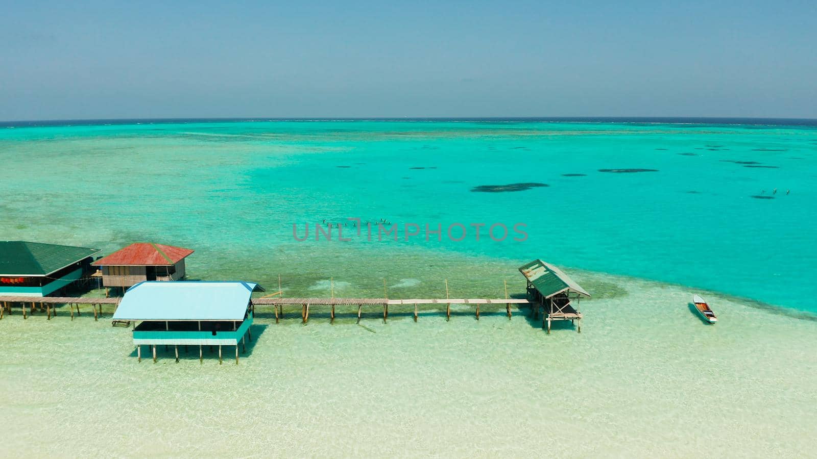 Seascape with beautiful beach and tropical island surrounded by a coral reef from above. Onok Island, Balabac, Philippines. Summer and travel vacation concept