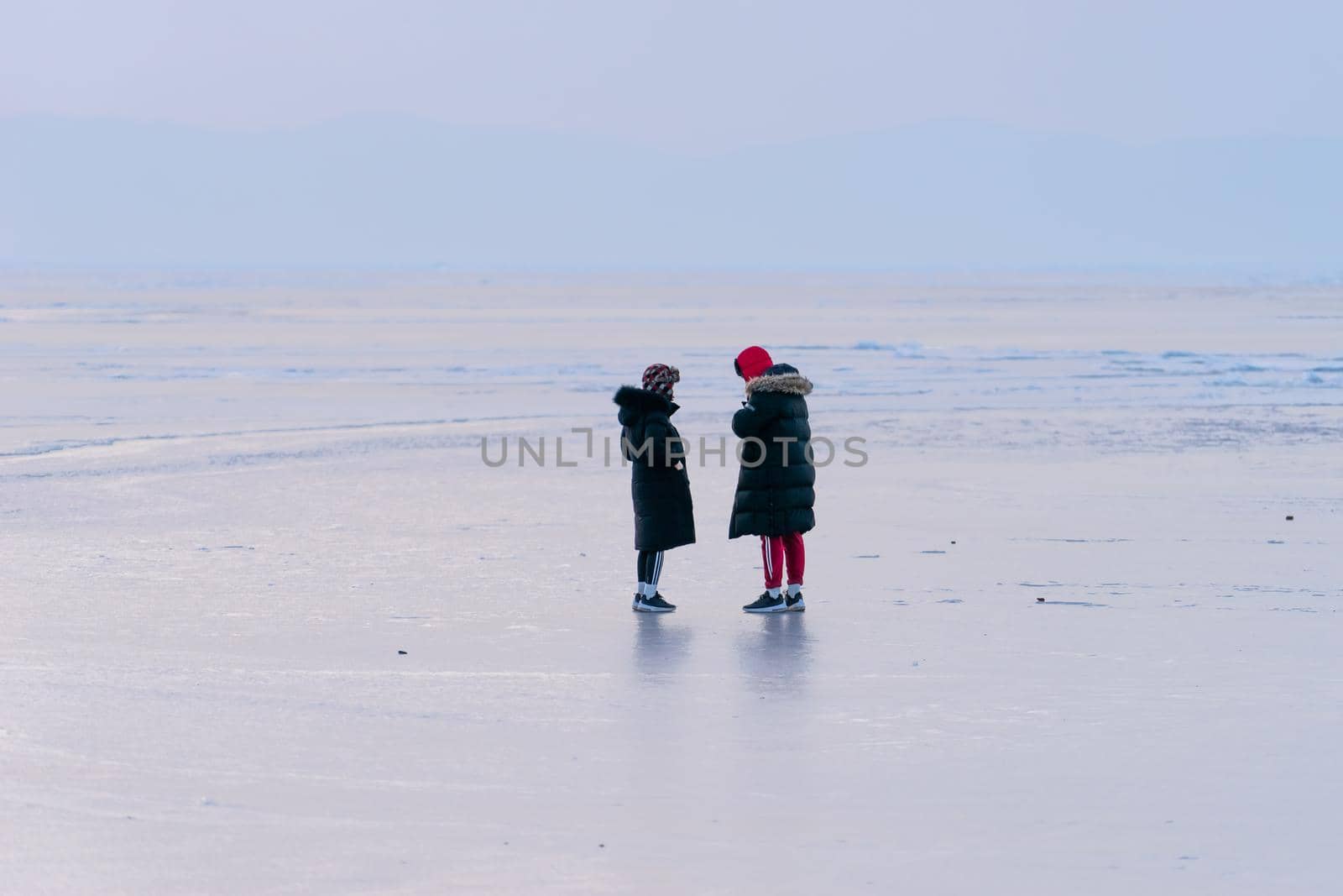 Vladivostok, Primorsky Krai. People in winter clothes standing on the icy surface of the sea.